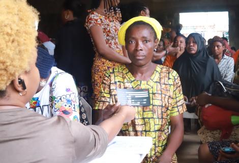 A beneficiary of the SPA II intervention receiving her card with her details