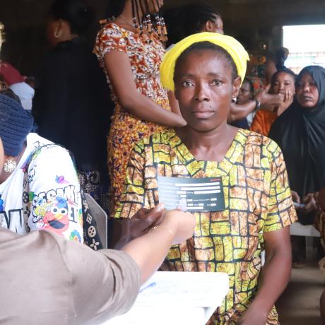 A beneficiary of the SPA II intervention receiving her card with her details