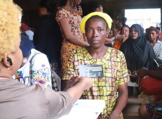 A beneficiary of the SPA II intervention receiving her card with her details